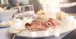 Vitello tonnato italien antipasto. Cold sliced veal with tuna sauce. Mediterranean lifestyle with bright bokeh in a restaurant.