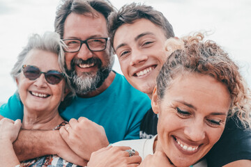 Mothers and sons concept. Two couple of adult mothers with their sons embracing and smiling expressing love friendship support