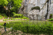 Beautiful view of Lucerne's famous lion monument carved in stone, nestled in a rocky grotto in a charming park where visitors can admire this mournful and moving masterpiece of stone.