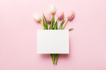 composition with blank card and beautiful flowers tulip on coloredbackground. top view with space fo
