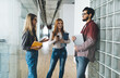 Positive diverse students chatting in corridor during break