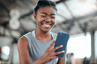 © Beaunitta Van Wyk/peopleimages.com - Social media, happy or black woman with phone in gym to search for a sports blog in training or exercise. Fitness app, smile or healthy girl athlete relaxing or reading online mobile content on break