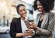 © Delmaine Donson/peopleimages.com - Happy business people, friends and phone in city for social media, communication or texting on street sidewalk. Woman employees or colleagues smile on mobile smartphone for networking in a urban town