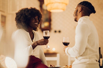 African american couple having romantic date at home while drinking wine