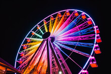 Ferris Wheel Ride Glowing In The Dark In An Amusement Park, Fairground Rides On Outdoor Area, Entertainment Activity. Generative AI