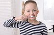 © New Africa - Cute little girl brushing her teeth with plastic toothbrush in bathroom