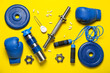 Composition with sports equipment, bottle of water and amino acid supplements on yellow background