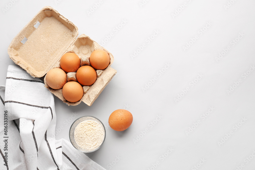 Glass with wheat flour and eggs in package on white background