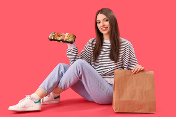 Sticker - Young woman with sushi and paper bag sitting on red background