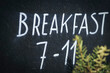 Breakfast times in a hotel hand written on a blackboard