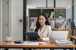 © chartchai - A beautiful and professional Asian businesswoman using her laptop to manage his tasks, working at the office.