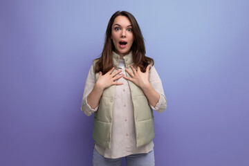 Wall Mural - surprised young brunette woman on purple background