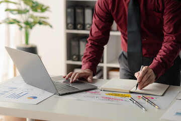 Wall Mural - A financier is reviewing company financial documents, monthly financial statement summary from the finance department. The concept of managing the company's finances for accuracy and growth.