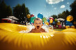ein Baby planscht im gelben aufblasbaren Schwimmbecken