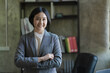 © Songsak C - Confident Asian businesswoman arms crossed thinking of new ideas at the office. Looking at the camera.