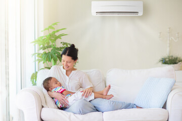 Mother and child with air conditioner remote