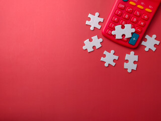 Top view red calculator with white puzzle on a red background