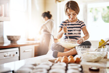 Messy, Flour And Girl Baking In A Kitchen With Parent For Learning About Independence, Child Development Or Food At Home. Dirty, Fun Or Young Female Kid Mixing Cake Or Cookies In A Bowl While Cooking
