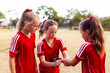 © Austockphoto - Soccer players help one another prepare for training