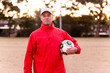 © Austockphoto - Portrait of male football coach wearing a cap and holding ball