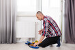 © Angelov - Repair heating radiator close-up. man repairing radiator with wrench. Removing air from the radiator.