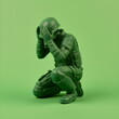 green army man toy crouched covering head isolated on plain studio background