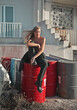 © olly - young beautiful woman sitting on metal cans