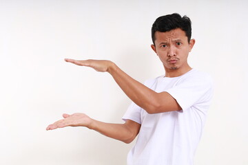 Wall Mural - Asian funny man standing while holding something. Isolated on white background