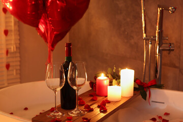 Canvas Print - Wooden tray with wine, burning candles and rose petals on tub in bathroom. Valentine's day celebration