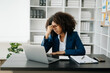 © Nuttapong punna - Overworked young African businesswoman office worker suffering from neck pain after had a long day at her office table. office syndrome concept