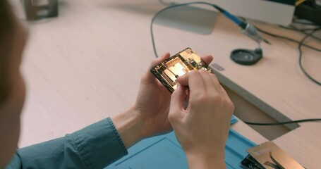 Wall Mural - man fixing smartphone motherboard in laboratory concept of computer hardware, mobile phones, electronics, repairs, upgrades technology Repairing and upgrade gadgets