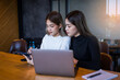 © EduLife Photos - Two cheerful young Asian female college students working on the school project using laptop computers and tablets together in private study room