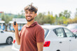 © luismolinero - Young Arabian handsome man holding car key at outdoors smiling a lot