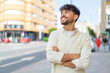 © luismolinero - Young Arabian handsome man at outdoors looking up while smiling