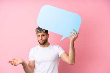 Wall Mural - Young handsome caucasian man isolated on pink background holding an empty speech bubble and having doubts