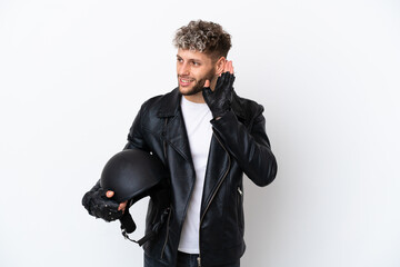 Wall Mural - Young man with a motorcycle helmet isolated on white background listening to something by putting hand on the ear