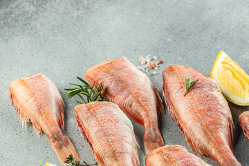 Canvas Print - fish, red snapper with lemon, rosemary, salt on a light background. Healthy food concept. place for text, top view