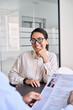 © insta_photos - Smiling professional Asian business woman candidate and hr manager employer holding cv resume during job interview sitting in office at meeting. Human resources concept. Over shoulder vertical shot.
