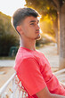 © cocopicfotografia - Apuesto y guapo joven, sentado con el sol detrás ejerciendo un maravilloso brillo en perfil, con colores cálidos e impresionantes.