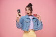surprised Asian young girl using smartphone and showing credit card isolated on pink background. wow discount and promotion online shopping concept.