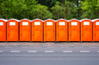 © Jarama - A line of orange plastic portable chemical toilets