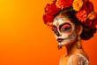 Attractive woman with day of the dead makeup on orange background