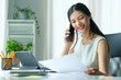 © wattana - Professional businesswoman having phone conversation with her business partner.