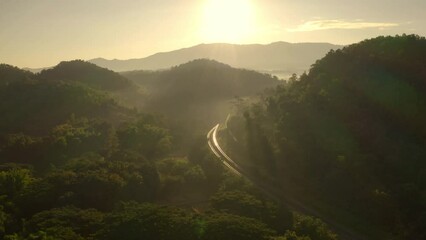Wall Mural - drone footage flying over the railway line in the morning. on the top of the tree towards the sun be