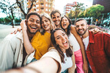 Fototapeta Londyn - Multicultural friends taking selfie pic with cellphone outside - Happy young people having fun hanging out on city street - Summer vacation concept with guys and girls enjoying summertime holiday