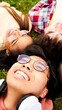 © CarlosBarquero - Portrait of a multiracial group of young smiling people. These friends lay on the grass being happy and positive. Generation Z community having fun together outdoors. Multi-ethnic students