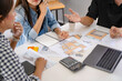© mojo_cp - Asian Architects designer team working together meeting in startup office