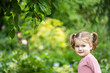 toddler girl with a bully face is outdoors among nature