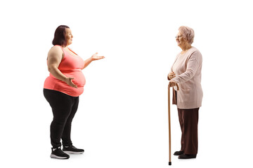 Sticker - Full length profile shot of an overweight young woman in sportswear talking to an elderly woman