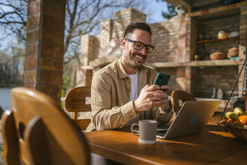 Wall Mural - One adult man in front house in day use smart phone video call or sms